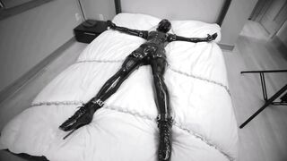 Girl tied and chained on the bed in Latex bondage with vibra