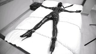 Girl tied and chained on the bed in Latex bondage with vibra