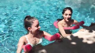 Two Bikini Teens challenging each other in pool