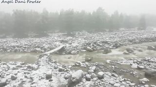 Angel Fowler Walks with Umbrella in Snow next to River