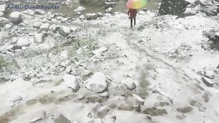 Angel Fowler Walks with Umbrella in Snow next to River