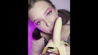 Lucky banana in the mouth of a girl with braces. Eye contact