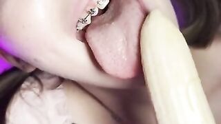 Lucky banana in the mouth of a girl with braces. Eye contact