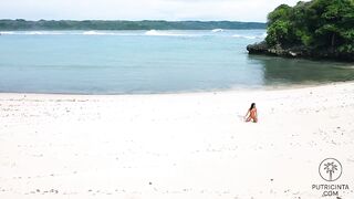 Putri Cinta stripping on a beautiful tropical beach