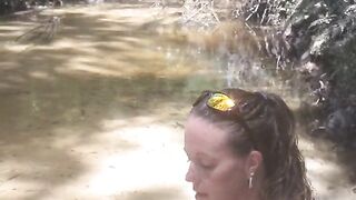 Country Girl Crawling On Her Hands and Knees In Water At Popular Spring Creek