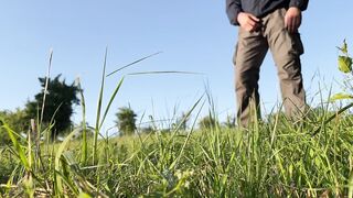 Mother-in-law in a dress bent over deeply to show you how she pees in nature